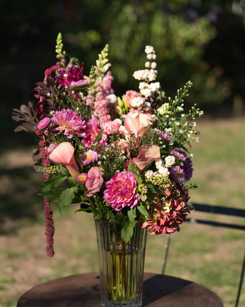 Bouquet rose et blanc dans un vase sur une table de jardin