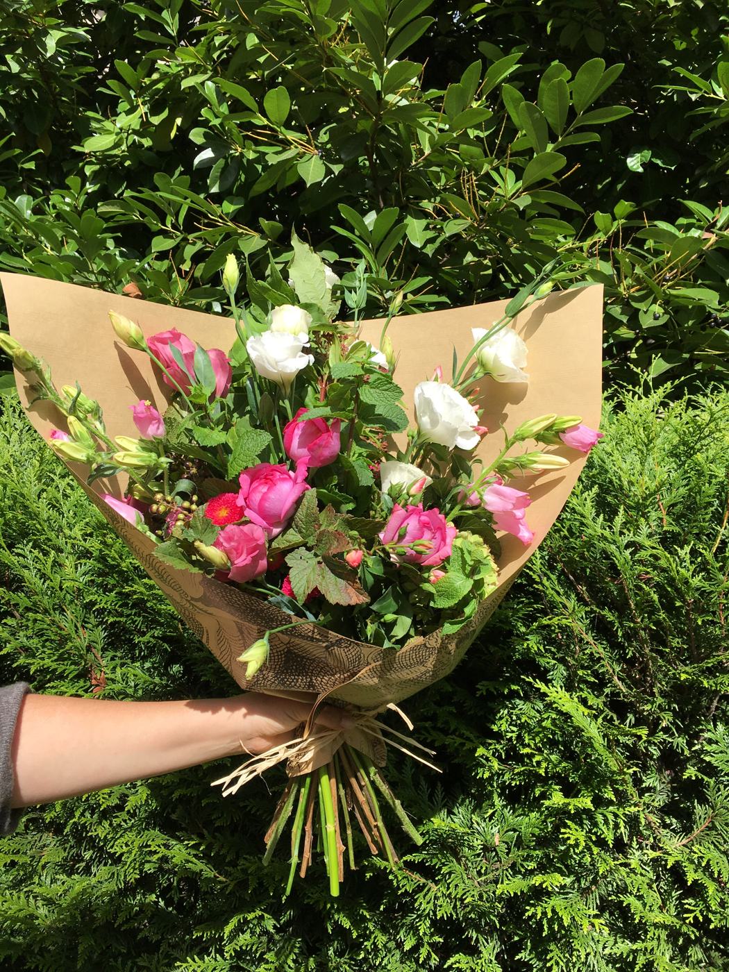 Bouquet de roses et lisianthus emballé dans du papier kraft